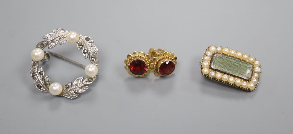 A Regency yellow metal seed pearl mourning brooch, a pair of 9ct garnet ear studs and a brooch stamped silver